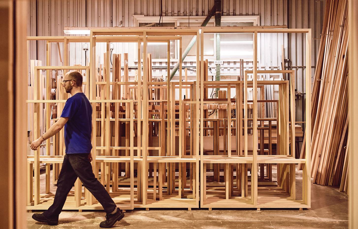 Worker walking in front of wooden windows frames